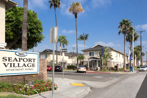 Seaport Village exterior with driveway entrance and palm trees. 5601 entrance sign