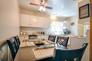 Affordable Apartments in Long Beach, CA - Seaport Village Apartments - Kitchen with White Cabinets, Light Countertops, Window, and White Appliances