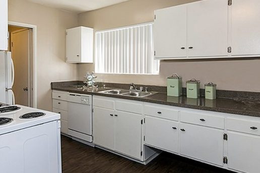 kitchen with white cabinets, granite countertops, window, white appliances