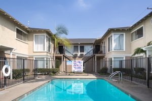 Affordable Apartments for Rent in Long Beach - Seaport Village Apartments - Fenced in Swimming Pool and Exterior of Building